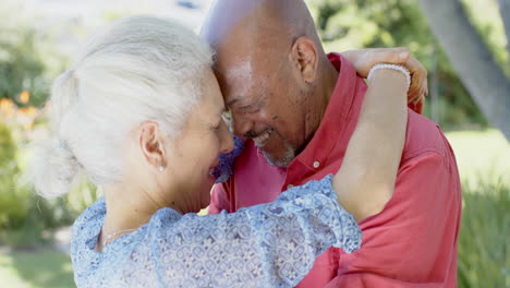 Feliz-Pareja-Birracial-Mayor-Bailando-En-El-Soleado-Jardín-De-Casa,-Cámara-Lenta