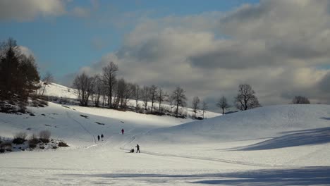 Blick-Auf-Eine-Verschneite-Landschaft-Mit-Wolken-Im-Hintergrund-Und-Sich-Erholenden-Menschen