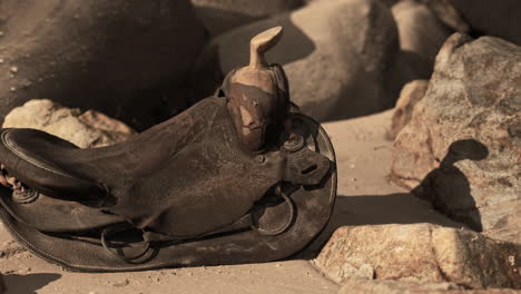 very old horse saddle on sand beach