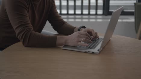 blogger writes letter on laptop sitting at round table