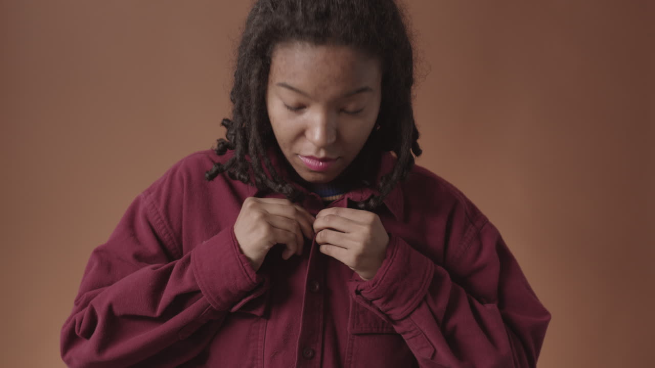 Affascinante donna afroamericana che si abbottona la camicia