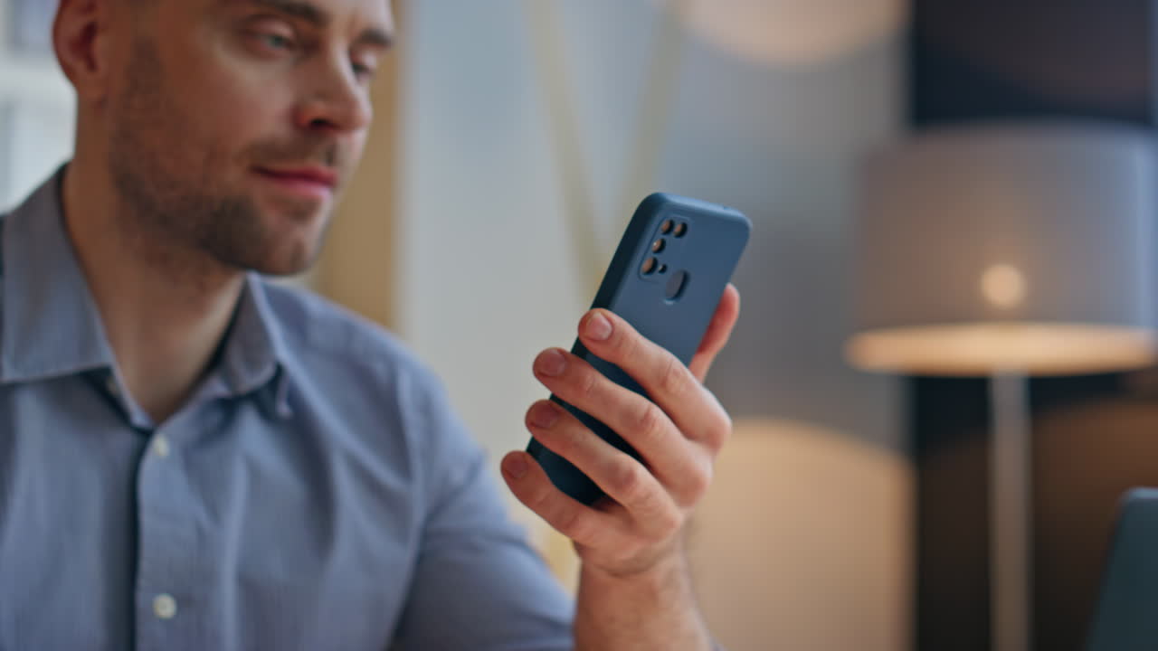 Man hands holding cellphone in office closeup. Handsome professional using phone