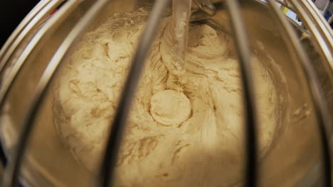 close-up of dough mixing in a professional kneader machine in kitchen of bakery or at the manufacturing. stock footage. dough making process