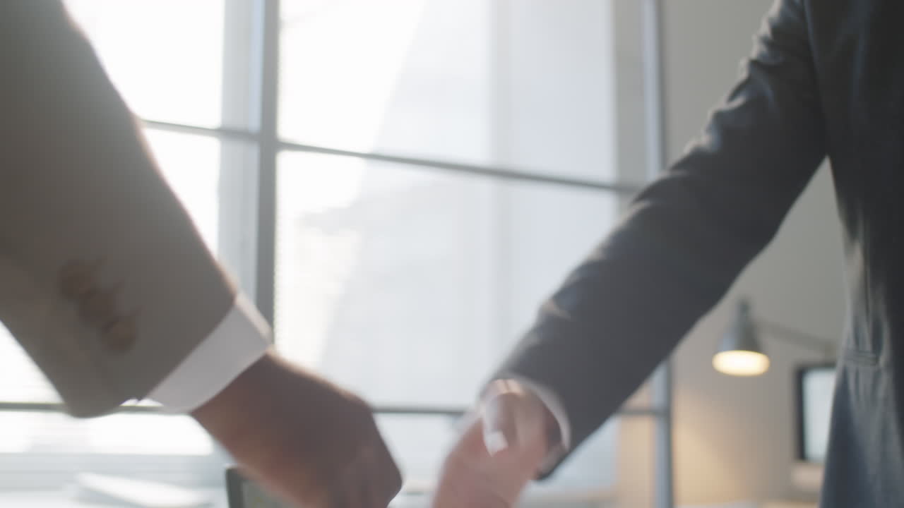 Uomini d'affari multietnici che si stringono la mano in ufficio