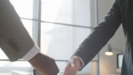 multiethnic businessmen shaking hands in office