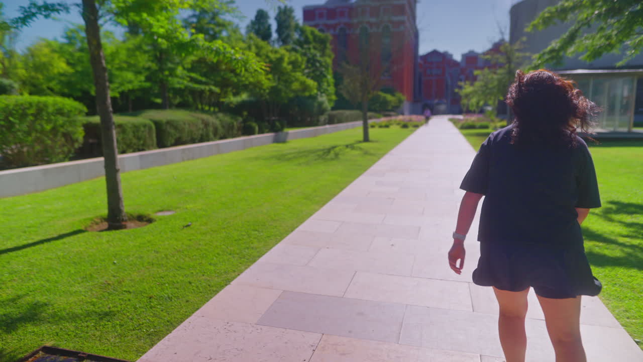 Woman walking in a city park on a sunny day