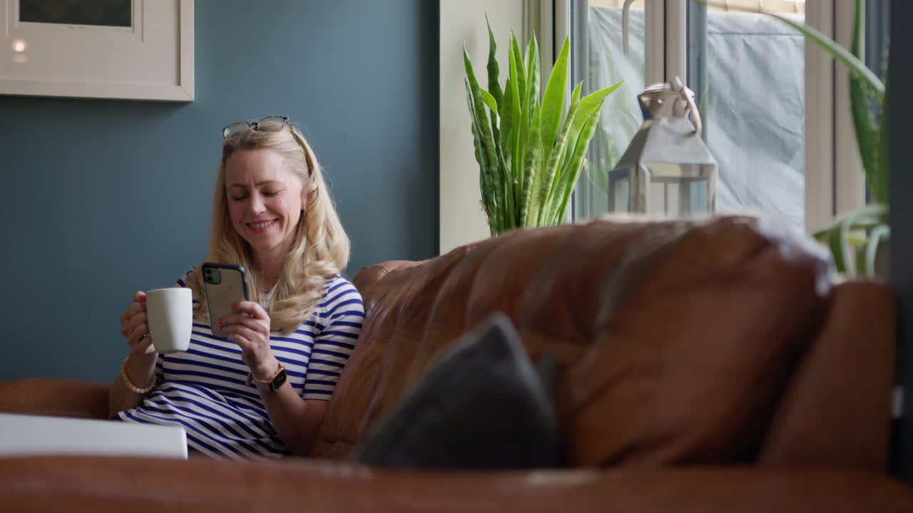 Woman Relaxing on Couch with Coffee and Phone