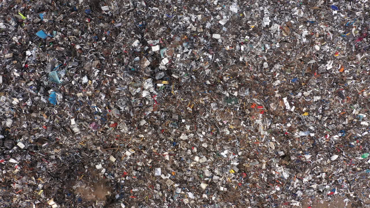 vuelo de imágenes de drones de ojo de pájaro a lo largo de una gran pila de chatarra