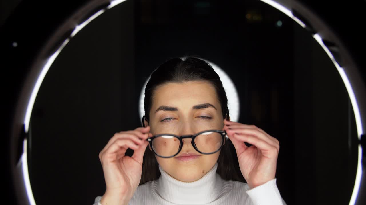 mujer con gafas sobre iluminación blanca en negro