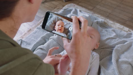 happy mother taking photo of baby using smartphone enjoying photographing cute toddler sharing motherhood lifestyle on social media