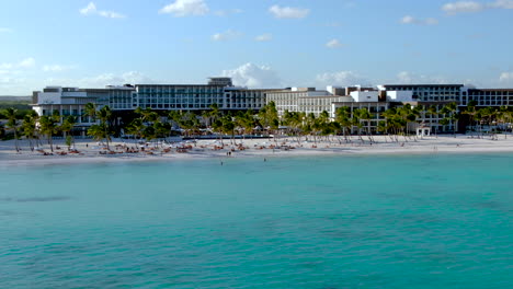 Estilo-De-Vida-De-Lujo-En-Un-Resort-Tropical-Paraíso,-Vista-Aérea-De-La-Playa-Romántica-Y-Resort-En-República-Dominicana,-Gente-Nadando-En-El-Mar-Turquesa