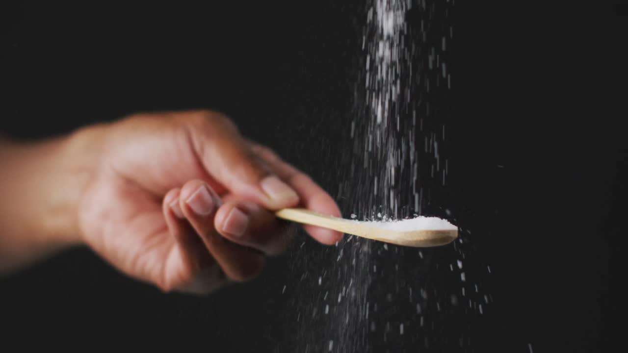 검은 배경 에 있는 테이블 에 소금 을 던지는 요리사 의 동영상