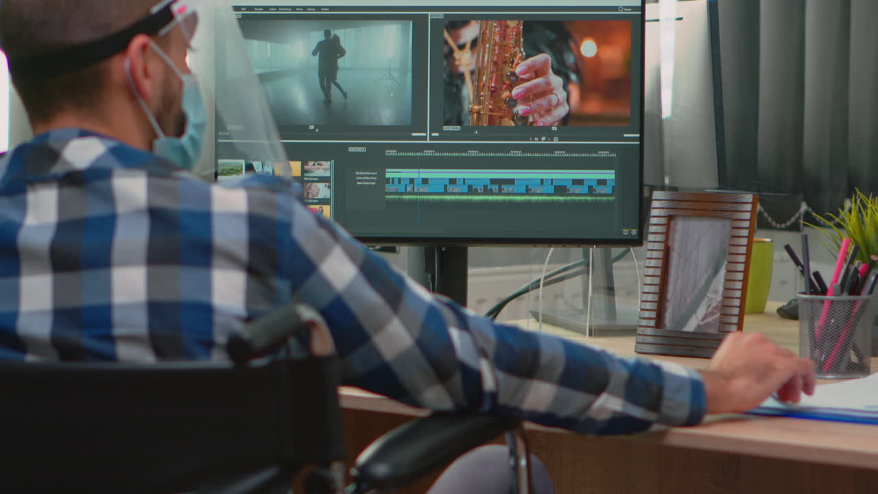 Disabled man with face protection against covid19 editing video
