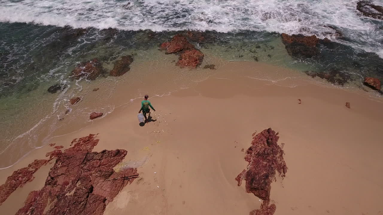 retire las imágenes de drones de un pescador recogiendo su captura en la playa en cabo san lucas, méxico