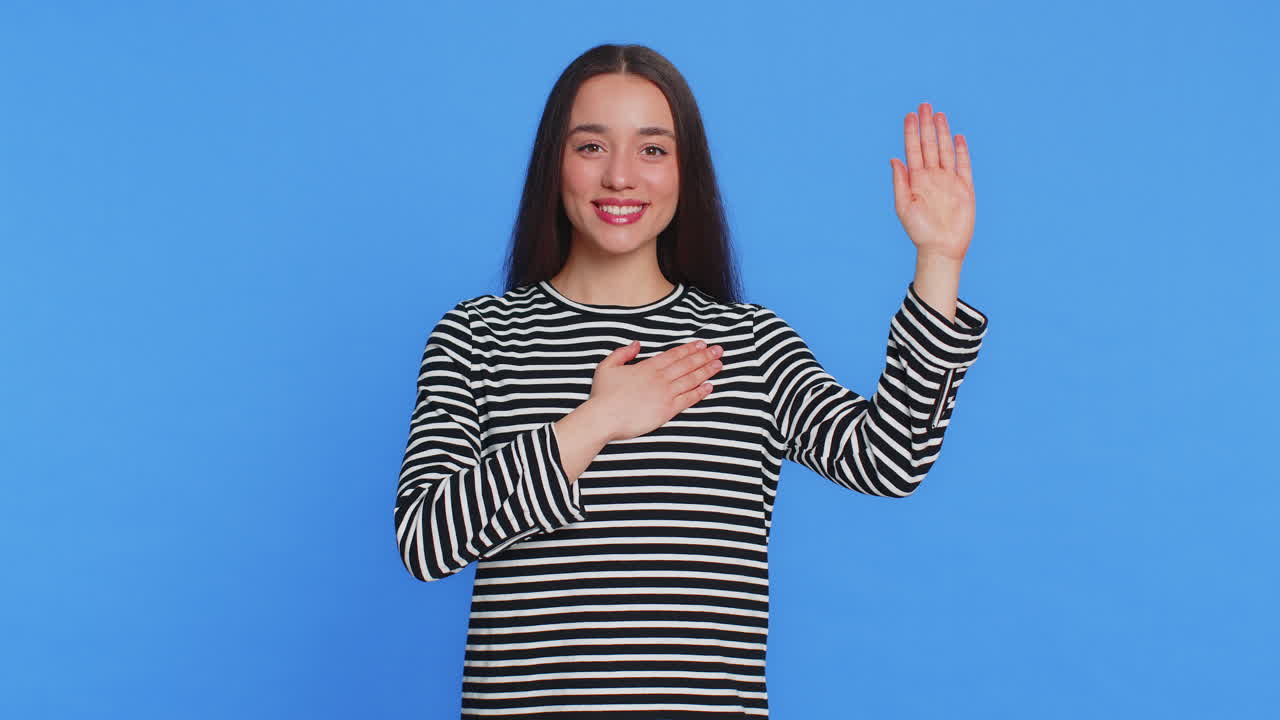 여자가 손을 들어 맹세를 하고, 정직하고 진실을 말하겠다고 약속하고, 가에 손을 고 있다.