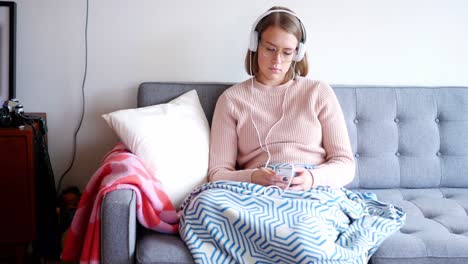 Woman-listening-to-music-with-headphones-from-her-mobile-phone