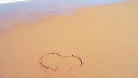 heart shape romantic on the sea beach and splashing waves on the sand with the slow motion wave in nature concept