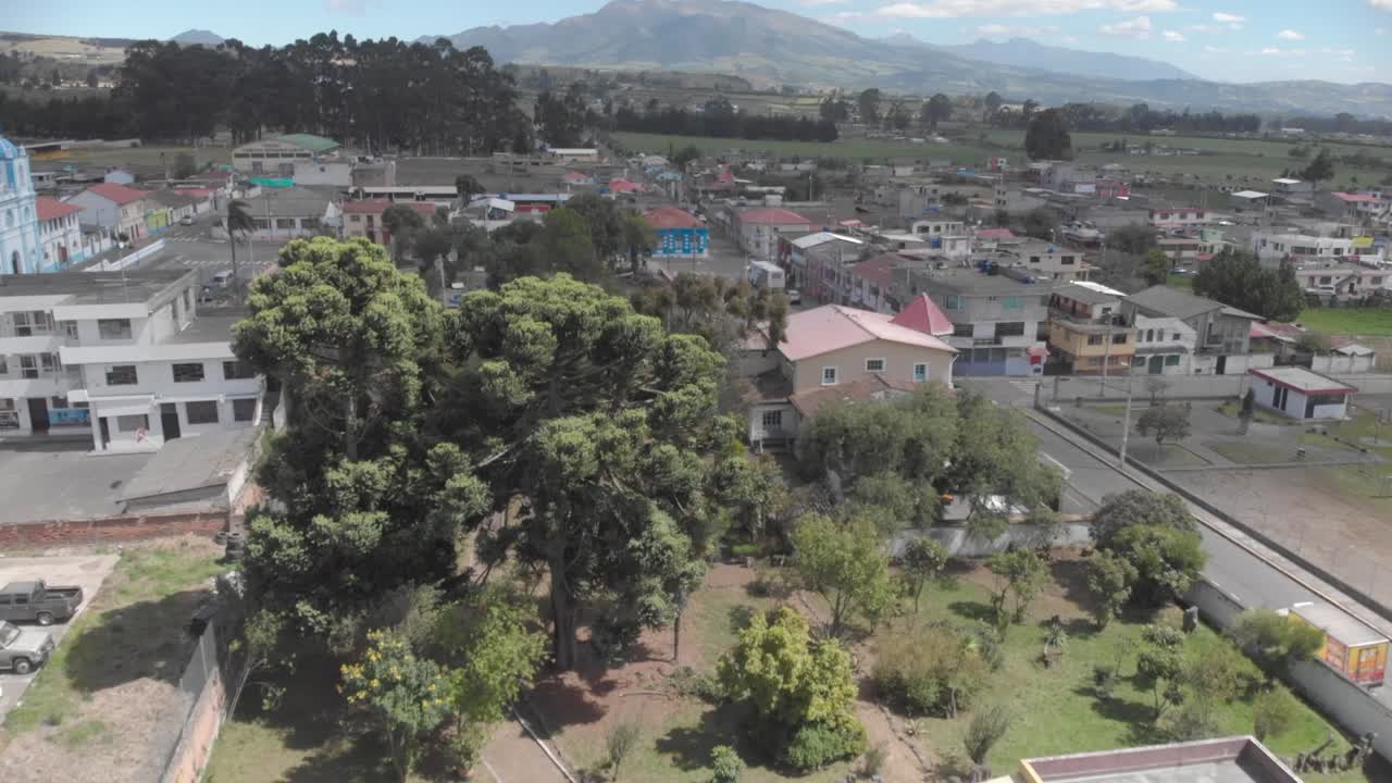 Veduta aerea di alcune case rustiche ad Aloasi, un parcheggio, alcune strutture e un'ampia vista panoramica del parco