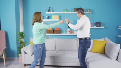 padre y joven hija adulta bailando en casa.