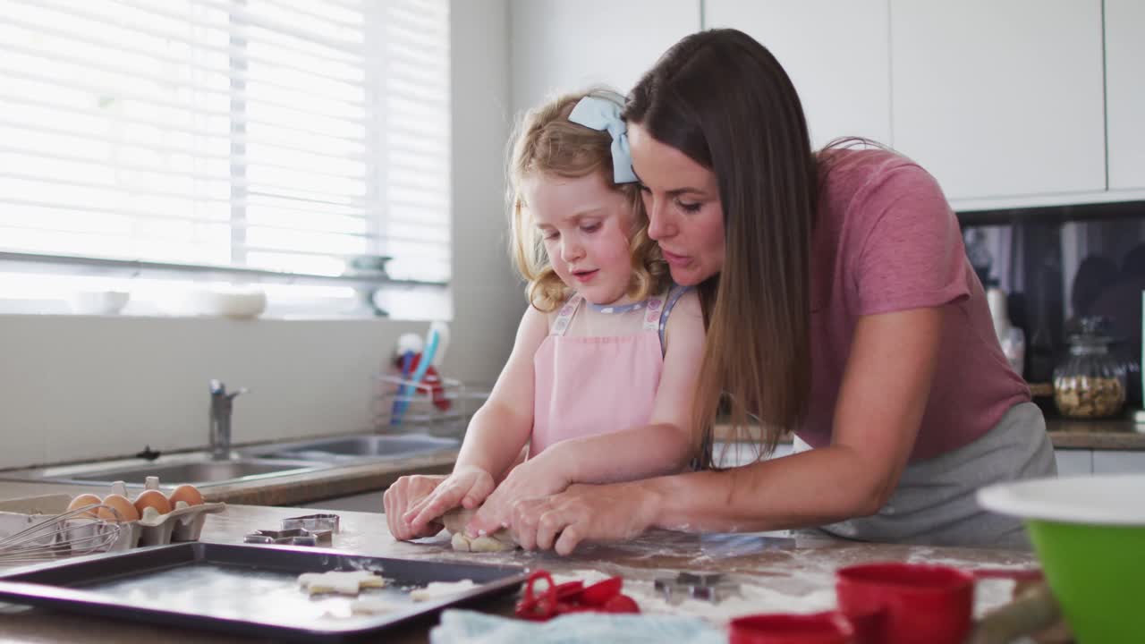 madre y hija caucásicas divirtiéndose cocinando juntas