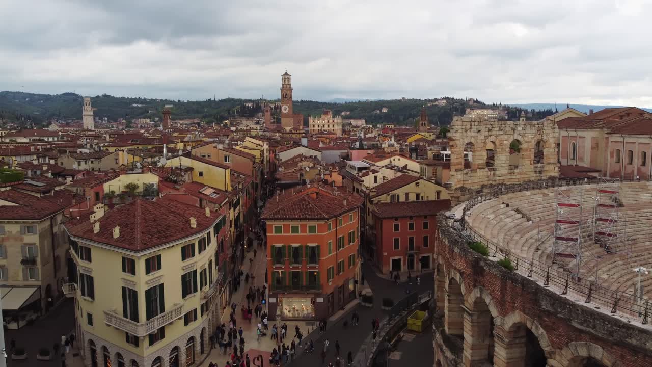 Verona's historical center with rooftops, the arena, and scenic hills, aerial view