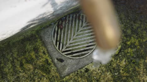 close-up of a water drain with a brass pipe