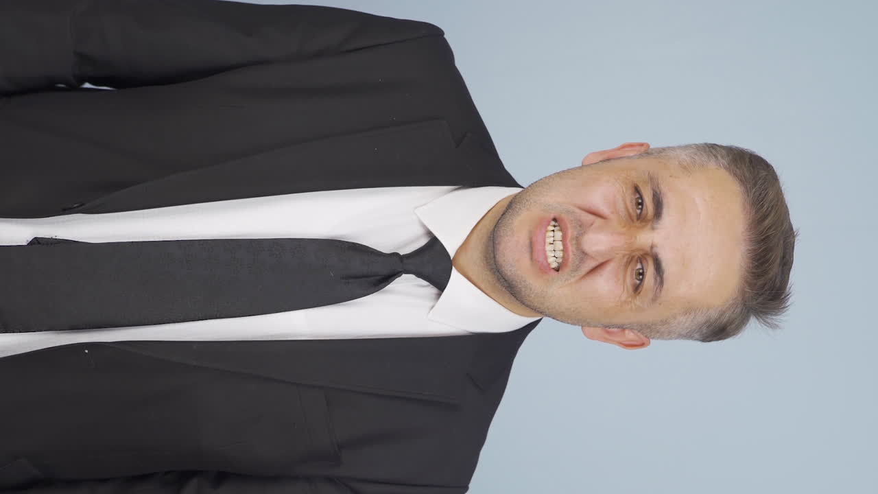 video vertical de un hombre de negocios enojado mirando a la cámara.