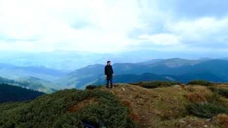 the happy man standing on the top of the mountain with a picturesque landscape