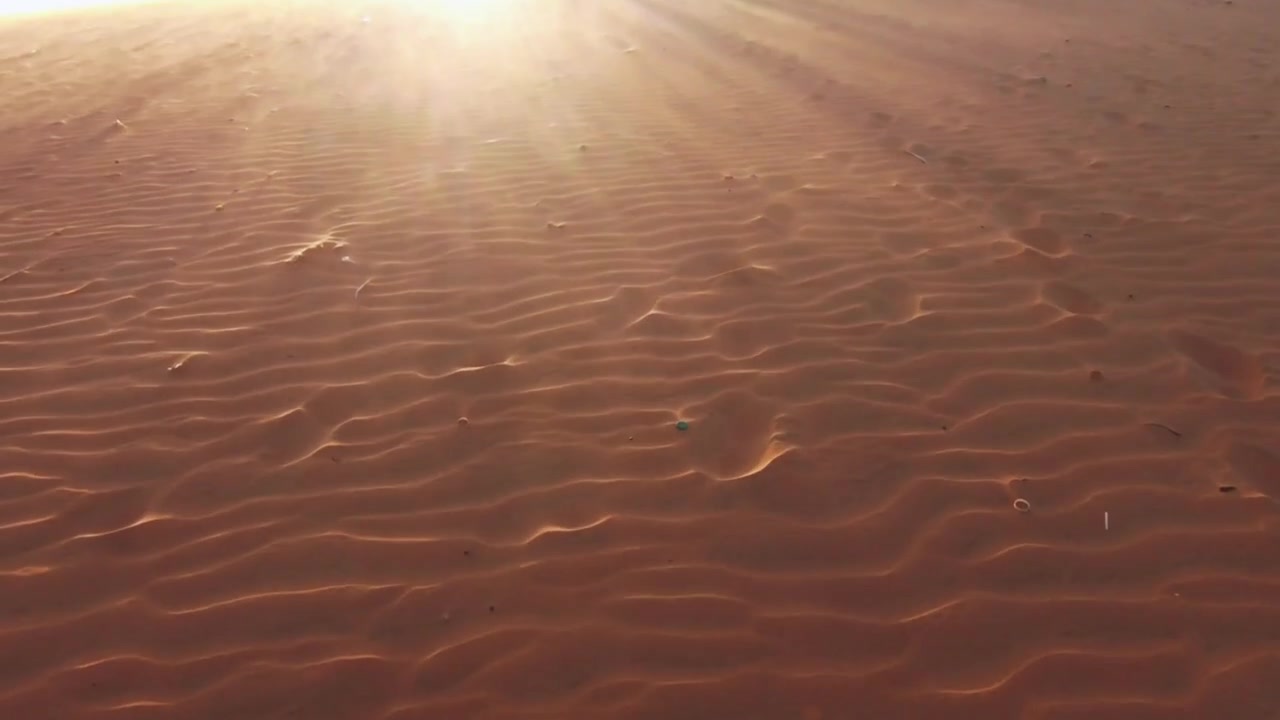Ripresa cinematografica con panoramica verso l'alto di sagome sull'orizzonte delle dune di sabbia del deserto