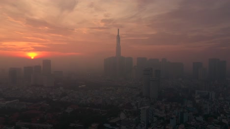 Tiro-De-Seguimiento-Aéreo-Urbano-Temprano-En-La-Mañana-Con-Niebla-Que-Muestra-El-Amanecer,-El-Río-Arquitectónico-Y-El-Cielo-Dramático