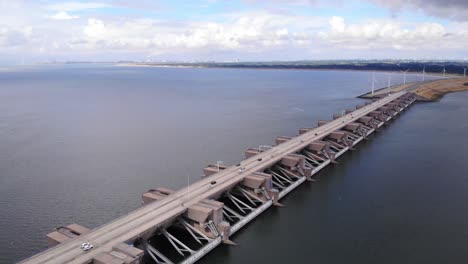 aerial static shot of vehicles passing on multilane motorway over haringvliet sluices in river estuary