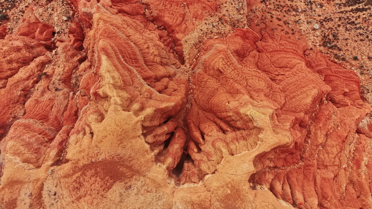 Le luminose pareti rosse del canyon mostrano segni di erosione in un vasto canyon durante il giorno.