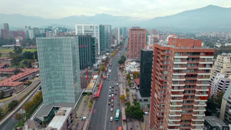 Ascending-establishing-flyover-over-Apoquindo-Avenue-in-Las-Condes,-an-affluent-business-district-of-Santiago,-Chile-on-a-cloudy-day