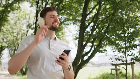 athletic fitness sport runner sportsman walking and using smartphone listening music with headphones