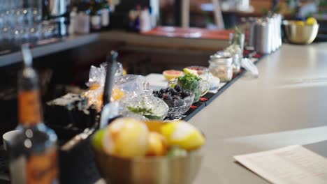 Bowl-of-lemons,-camera-tilting-up-to-showcase-fruits-and-vegetables-in-a-bar