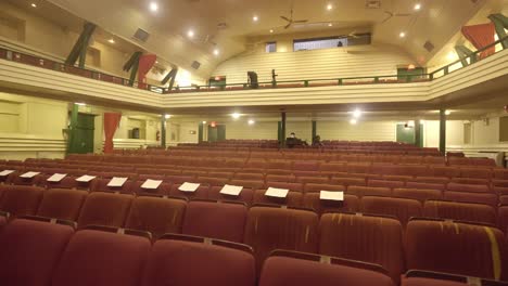empty red seats in thalia theatre with yellow lights