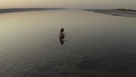 little girl bathes in a lake