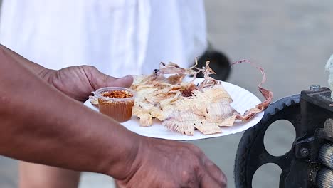 el vendedor sirve calamares a la parrilla a los clientes