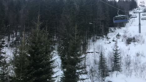 Closeup-of-vacant-ski-chairlifts-in-winter-pine-forest-at-Jahorina-mountain