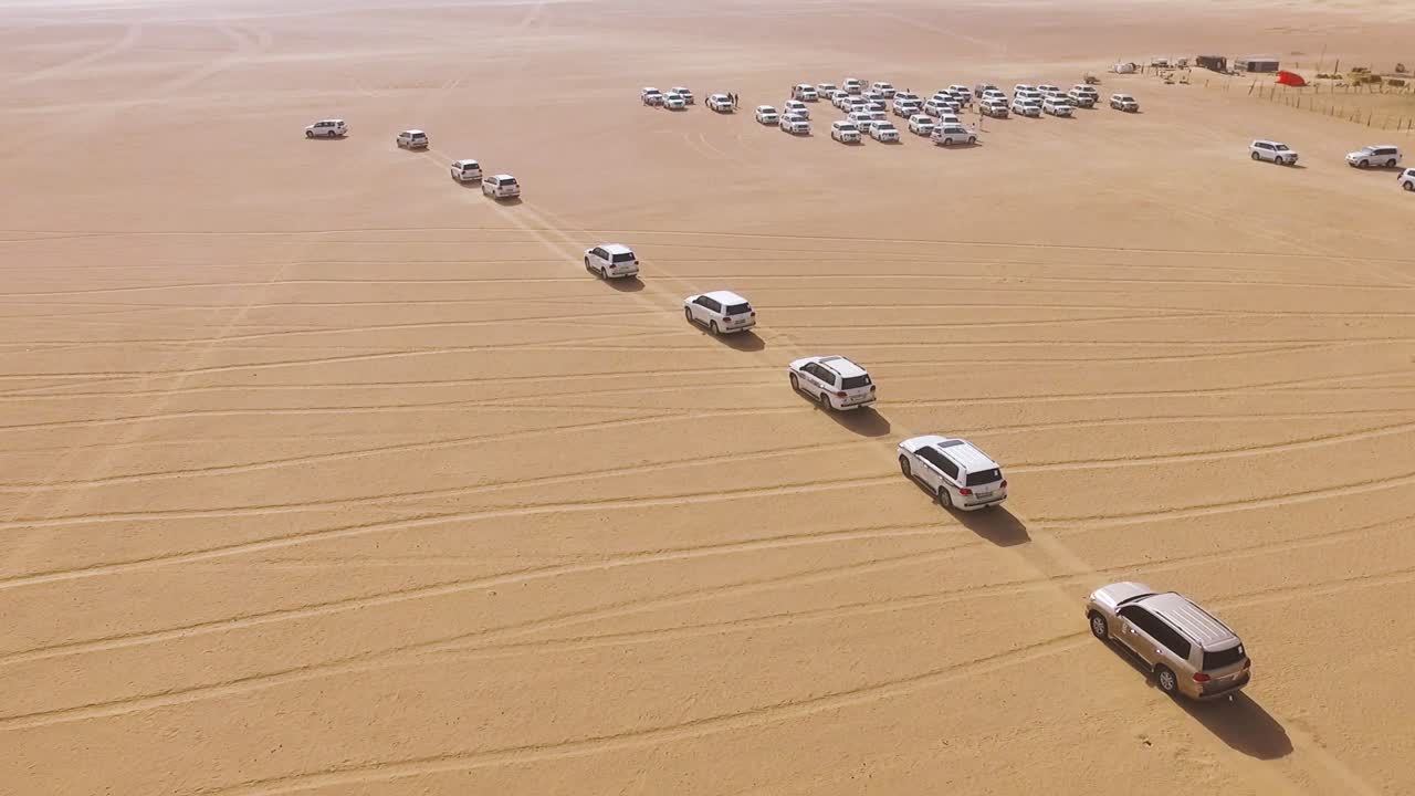 vista aérea de muchos vehículos blancos conduciendo a través del desierto