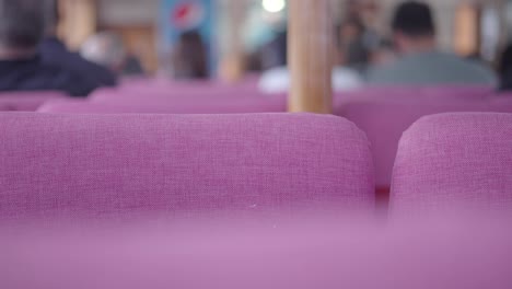 pink seats on a ferry/boat/ship with passengers