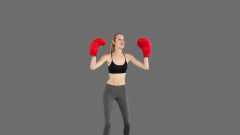 Fit-model-cheering-with-red-boxing-gloves