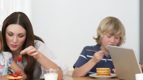 del panorama del padre usando una computadora portátil y la familia comiendo dulces
