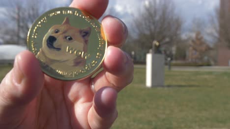 token de dogecoin con la estatua de satoshi nakamoto en el fondo