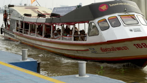 chao phraya express boat docking at the pier for daily passenger pickup and drop-off, facilitating water transportation and tourism in bangkok’s river system
