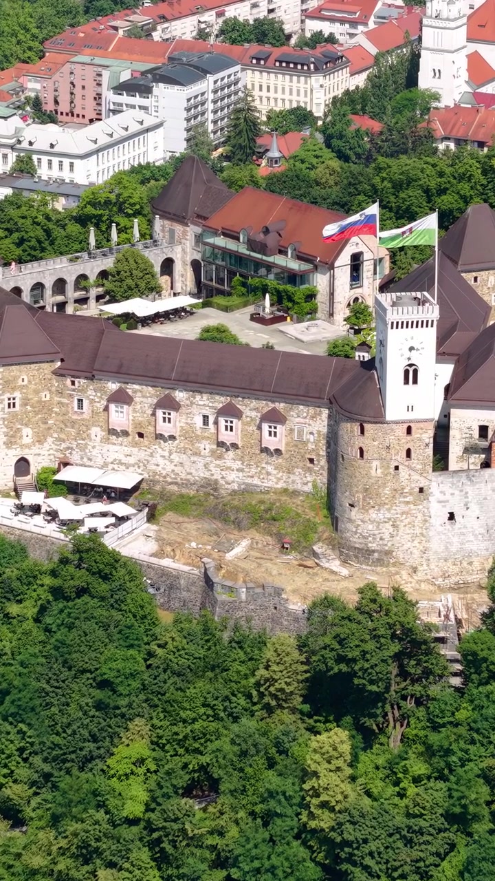 Vertikalt dronebilde av Ljubljana slott, Slovenia. Landemerke på en bakketopp over gamlebyen på en solrik dag.