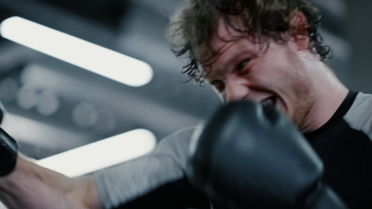 피트니스 센터에서 혼자 훈련하는 흥분된 전투기. 체육관에서 운동하는  ⁇ 박서