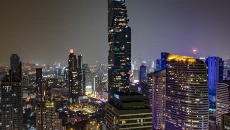 Das-Stadtzentrum-Von-Bangkok-Bei-Nacht-Mit-Belebten-Straßen,-Blick-Auf-Die-Atemberaubenden-Höchsten-Gebäude,-Die-Von-Hellen-Lichtern-Beleuchtet-Werden,-Filmischer-Hyperlapse