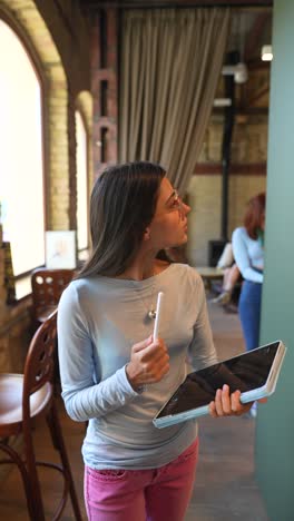 young woman using a tablet in a cafe/library