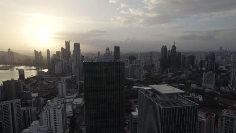 Panama-city-skyline-at-sunrise-with-modern-skyscrapers-and-hazy-skies,-aerial-view